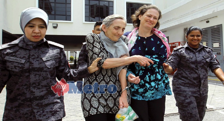 Catherine (dua kiri) bersama Leilanie yang dibebaskan daripada hukuman mati ditahan anggota Jabatan Imigresen Malaysia atas kesalahan visa tamat tempoh, hari ini. FOTO Danial Saad 