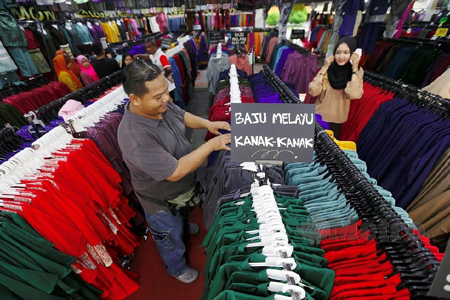 MOHD Suhaili menyusun baju Melayu di bazar pekarangan Pasaraya Yawata.  FOTO: Sharul Hafiz Zam