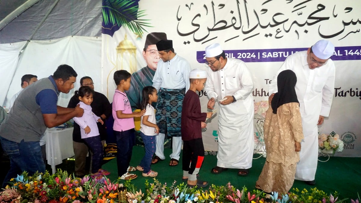 Dr Zulkifli Hasan (tiga dari kanan) menyampaikan sumbangan duit raya kepada kanak-kanak pada Majlis Mahabbah Aidilfitri di Maahad Tarbiyah Islamiah Derang, Pokok Sena, hari ini. FOTO BERNAMA
