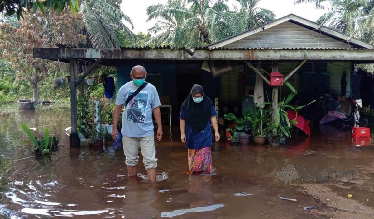 ANTARA rumah penduduk yang masih digenangi air banjir termenung di Kampung Bahru, Sri Gading. FOTO Essa Abu Yamin