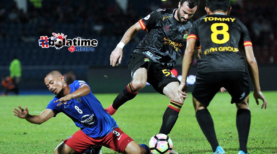 Pemain JDT Safiq Rahim terjatuh diasak pemain Sarawak Milos Raickovic. FOTO BERNAMA  