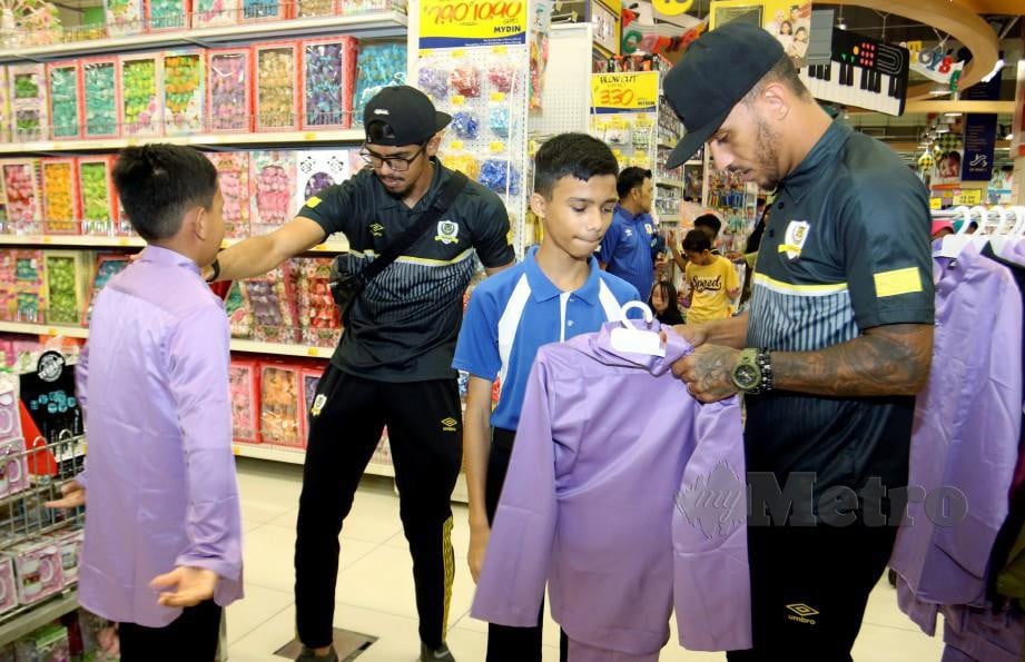 Leandro Dos Santos (kanan) bersama Muhammad Hafizul memilih baju raya untuk anak-anak yatim dari Pusat Jagaan dan Miskin Nurul Iman, Manjoi.