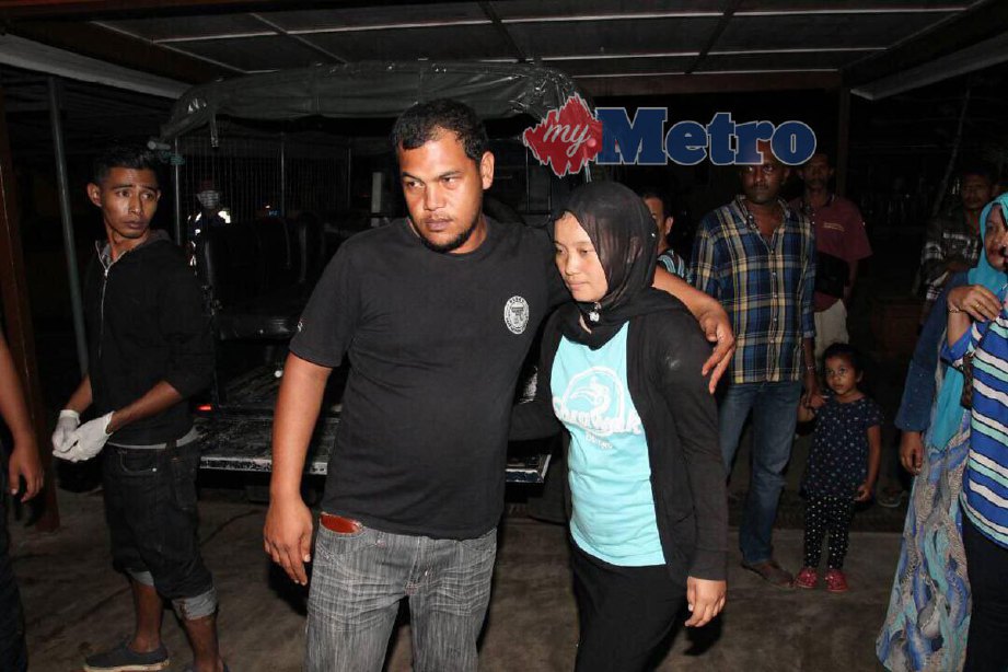 Bapa mangsa, Mohd Adli Mohd Noor, 34  mententeramkan isterinya setelah mayat Alif Aiman Mohd Adli, 12, ditemui. FOTO NIK ABDULLAH NIK OMAR
