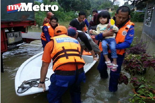 ANGGOTA JPAM membantu memindahkan mangsa banjir di Kampung Batu Kitang, Kuching. FOTO Jeaqkleyn Yacho
