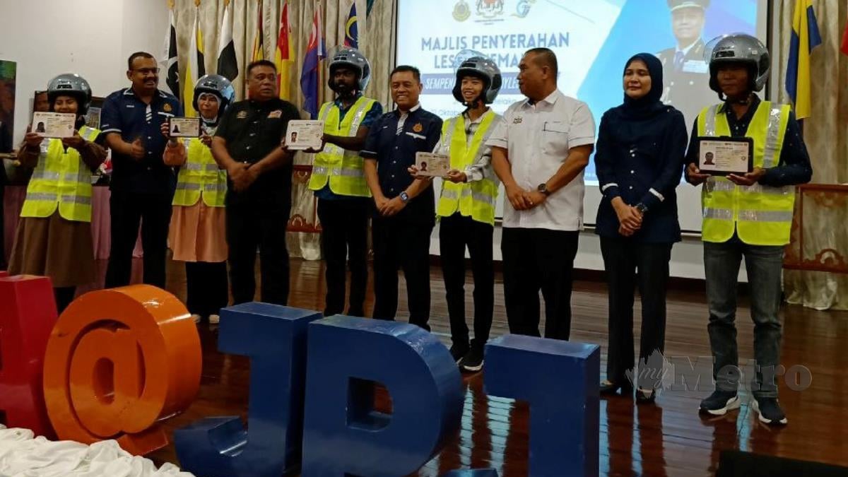 AEDY Fadly  (tengah) menyampaikan replika lesen motosikal B2 kepada peserta Program MyLesen B2 peringkat JPJ Melaka di Banda Hilir hari ini. FOTO Meor Riduwan Meor Ahmad.