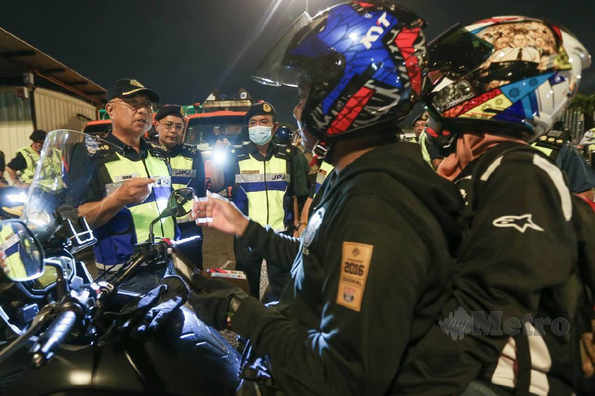 LOKMAN (kiri) memeriksa penunggang motosikal ketika Op Hari Raya Aidilfitri (HRA) 2023 di lorong motosikal Plaza Tol Jambatan Pulau Pinang di sini. FOTO Danial Saad