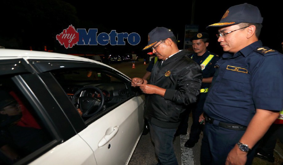WAN Ahmad Uzir melakukan pemeriksaan terhadap pemandu kereta dalam operasi di Jalan Dato' Muda Linggi, Seremban, semalam. FOTO Iqmal Haqim Rosman
