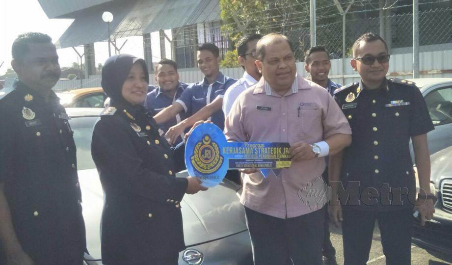 FATIMAH (kiri) menyerahkan replika kunci kepada, Mohd Jelani pada Majlis Penyerahan Kenderaan Sita ‘Scrap’ Lucut Hak Kepada Institut Pendidikan Negeri Perlis di Ibu Pejabat JPJ Perlis.FOTO Dziyaul Afnan Abdul Rahman