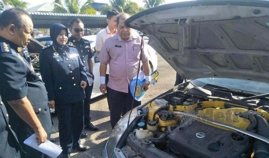 FATIMAH (kiri) bersama Mohd Jelani melihat enjin kereta yang diserahkan JPJ Perlis kepada Kolej Vokasional Arau. FOTO Dziyaul Afnan Abdul Rahman