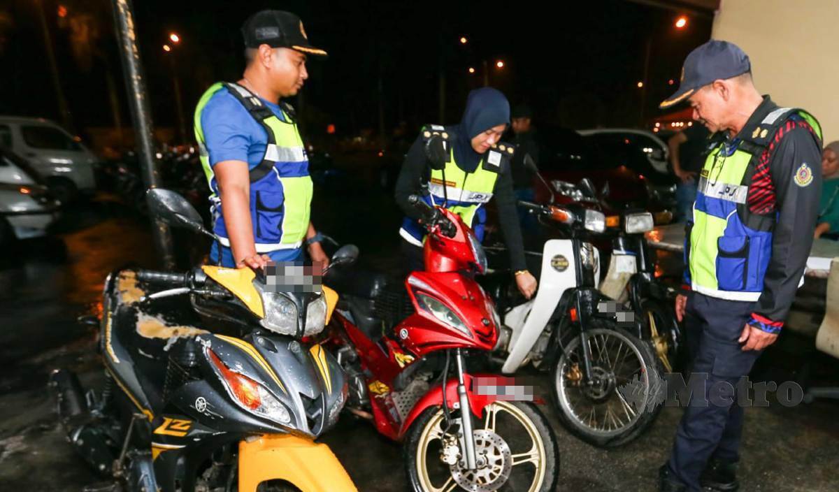 NAZILI (kanan) bersama anggotanya memeriksa motosikal yang  tidak mematuhi piawaian keselamatan bagi kegunaan di atas jalan raya selepas Operasi Khas Motosikal Negeri Kelantan 2023 di Stesen Penguatkuasa Labok. FOTO Nik Abdullah Nik Omar