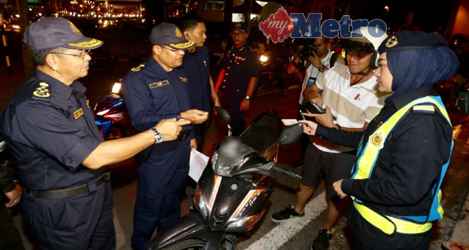 Shaharuddin Khalid (kiri) memeriksa penunggang motosikal dalam Ops Bersepadu JPJ Selangor di Plaza Tol Batu 9, Cheras, malam semalam. FOTO Mohd Khairul Helmy Mohd Din