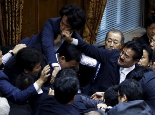 Speaker Yoshitada Konoike dikerumuni Ahli Parlimen dan Masahisa Sato (kanan) dari Parti Liberal Democratik yang memerintah menumbuk muka Ahli Parlimen pembangkang Hiroyuki Konishi. - Foto REUTERS