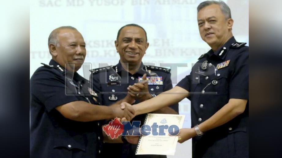 MD Yusof (kanan) menerima nota serah terima tugas jawatan Ketua Jabatan Siasatan Jenayah Johor daripada Kamaluddin (kiri) sambil disaksikan Mohd Khalil di IPK Johor, hari ini. Foto IZLAILY NURUL AIN HUSSEIN