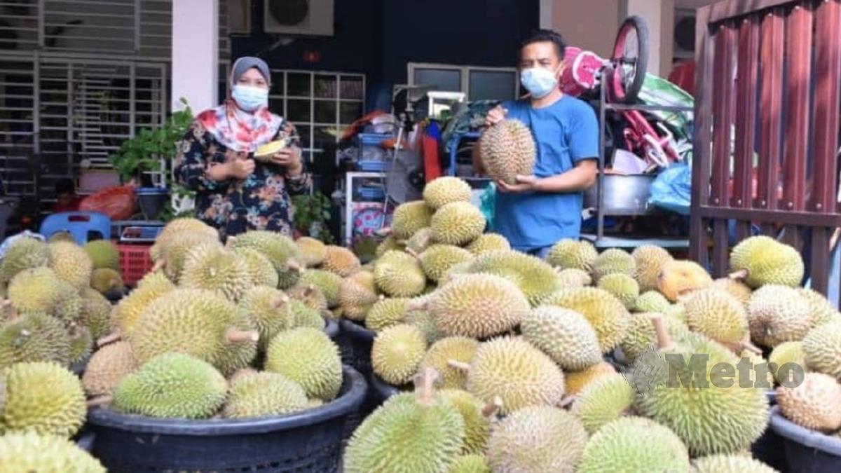 MOKTHAR dan Siti Balqis menunjukkan durian yang dijual melalui online. FOTO Roselan Ab Malek.