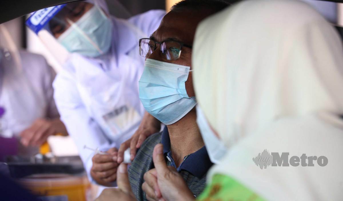 JURURAWAT memberi suntikan vaksin kepada sebahagian daripada 100 orang kumpulan pertama secara pandu lalu di Pusat Pemberian Vaksin (PPV) Covid-19 Daerah Kinta, di Perkarangan Stadium Indera Mulia. FOTO Sharul Hafiz Zam