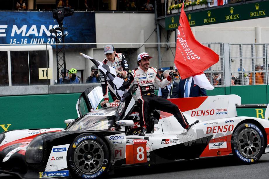 Alonso (kanan) bersama Nakajima dan jentera Toyota meraikan kejayaan perlumbaan Le Mans endurance 24 jam di Perancis. FOTO AFP