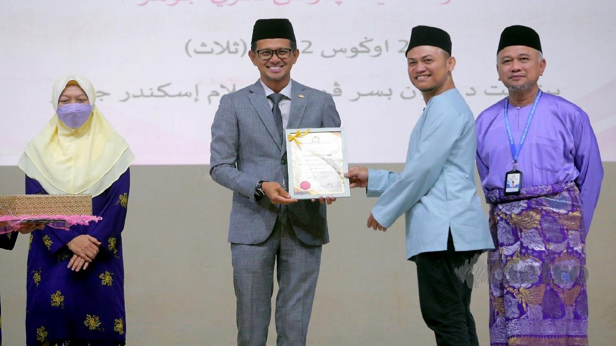 MOHD Fared (dua kiri) menyampaikan sijil penghargaan kepada Khairolizan (dua kanan) pada majlis Penutup Simposium Kaunseling Islam ‘Pelangi Islam’ Peringkat Negeri Johor di Dewan Besar Pusat Islam Iskandar Johor. FOTO NUR AISYAH MAZALAN