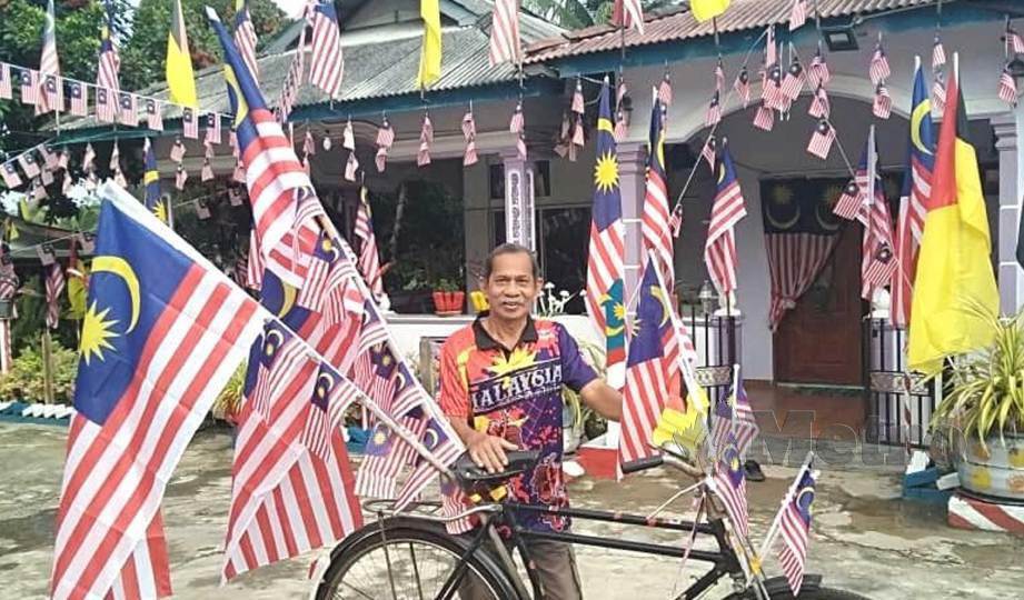 MOHD Jumaro bersama basikal tua miliknya yang turut dihiasi Jalur Gemilang. FOTO Abnor Hamizam