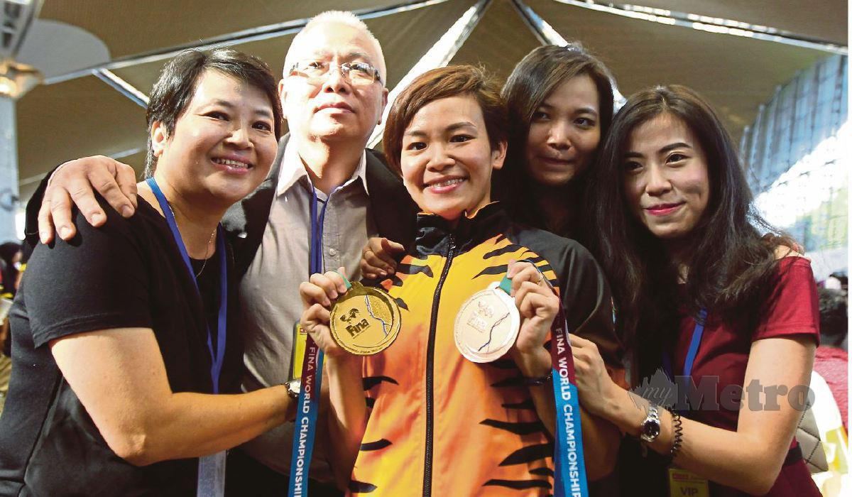 JUN Hoong (tiga kanan) meraikan kejayaan bersama kedua ibubapanya setelah memenangi pingat emas acara 10m platform individu wanita pada Kejohanan Dunia Konvederasi Renang Antarabangsa 2017.