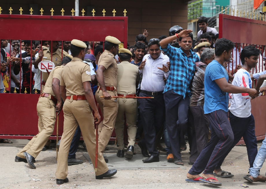 Anggota polis terpaksa dikerah untuk mengawal peminat ketika mereka memasuki pawagam di Chennai, selatan India. - Foto AP