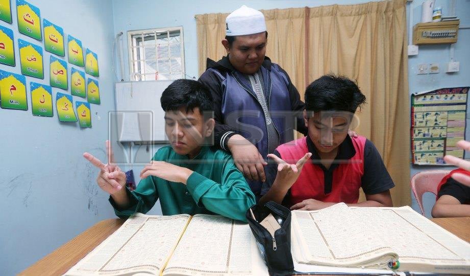 USTAZ Ahmad Rozaimi mengajar anak cacat pendengaran membaca al Quran dalam bahasa isyarat. FOTO Rohanis Shukri.