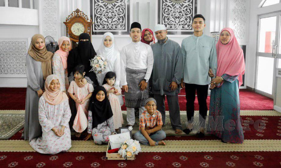 MUHAMAD Aqil Asyraaf dan Ummi Nadhirah bergambar dengan keluarga masing-masing selepas selesai majlis akad nikah, Sabtu lalu.