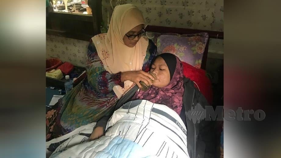 NURAIN dibantu ibunya, Hasnah Mahmood untuk minum selepas terlantar akibat menghidap penyakit buah pinggang pada Ogos tahun lalu di Kampung Kerawang, Machang. FOTO Hazira Ahmad Zaidi