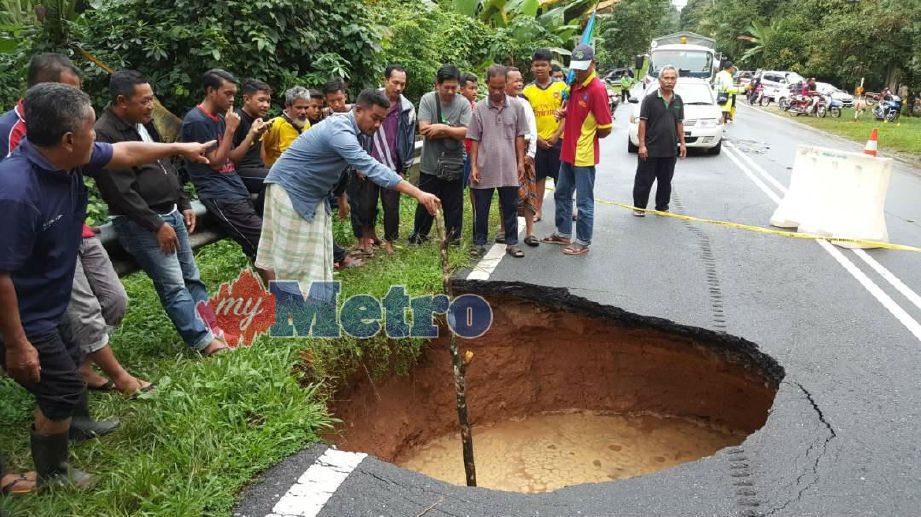 Penduduk kampung menunjukkan lubang yang terbentuk disebabkan berlaku tanah mendap di Jalan Jertih-Keruak. FOTO Mohammad Ishak