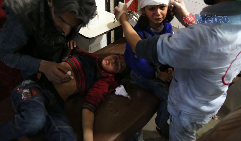 KANAK-KANAK yang cedera diberi rawatan di hospital sementara di Kafr Batna, semalam.  FOTO AFP