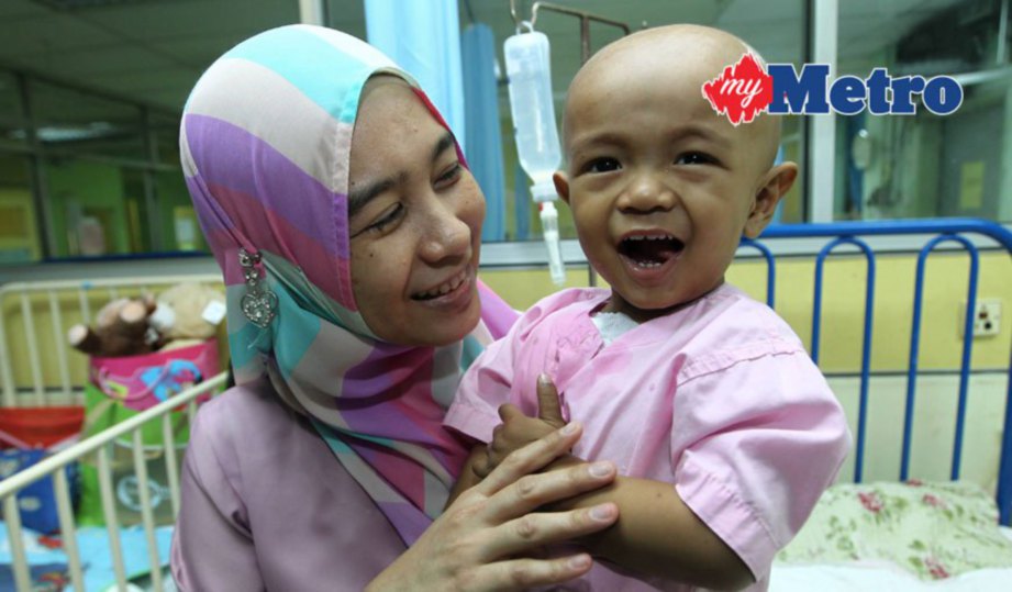 IKMAL Amilah bersama anaknya, Adi Haris (kanan) menghidap tumor menunggu tarikh pembedahan di Institut Pediatrik HKL.