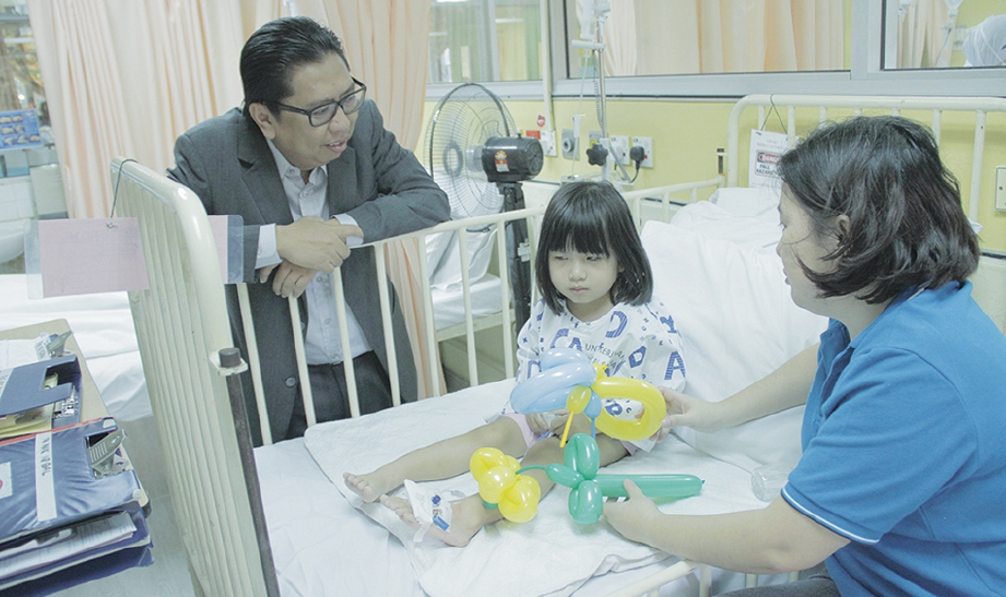 BUDIMAN bertanyakan khabar kanak-kanak pesakit kanser dalam lawatan YKM ke Hospital Kuala Lumpur.