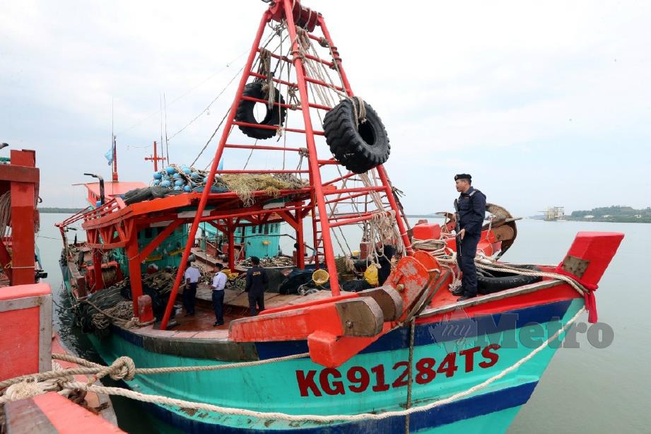 PASUKAN Maritim Malaysia melakukan pemeriksaan pada bot nelayan warga Vietnam yang ditahan. FOTO L Manimaran
