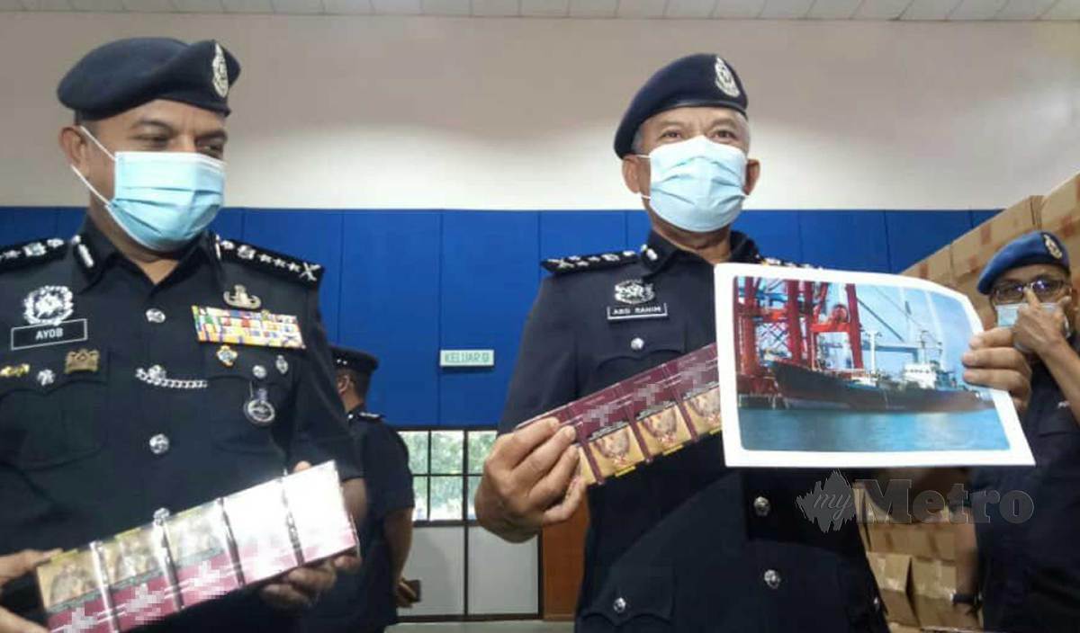 ABD Rahim (kanan) bersama Ketua Polis Johor Datuk Ayob Khan menunjukan rokok dan kapal kargo yang berjaya dirampas pada sidang media di Dewan Ibu Pejabat Polis Daerah Pontian.