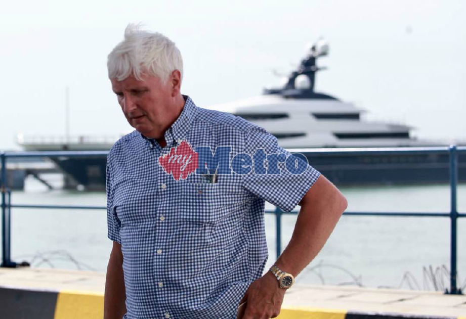 Kapten kapal The Equanimity, Oystein Senneseth berjalan berlatar belakangkan kapal mewah terbabit di Boustead Cruise Centre, Pelabuhan Klang. FOTO Sairien Nafis