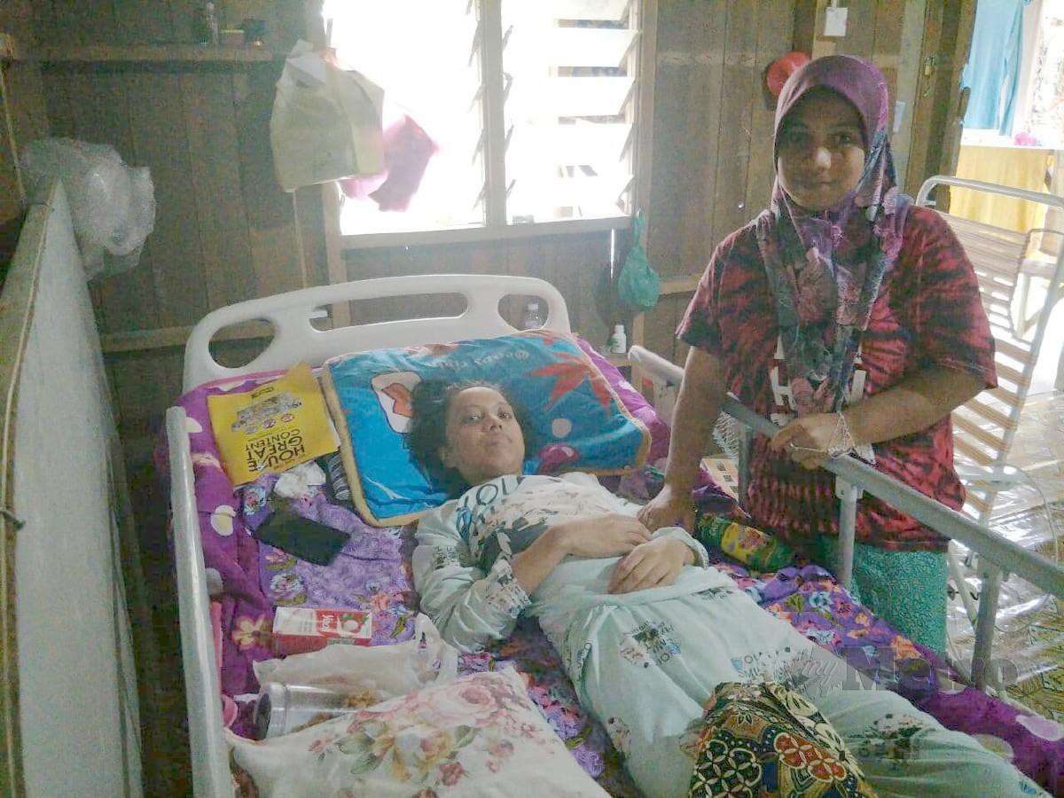 FAEZAH bersama anak perempuannya Nor Farihan Salwani yang menerima menerima sumbangan katil daripada individu yang prihatin dengan nasib mereka. FOTO Ramli Ibrahim