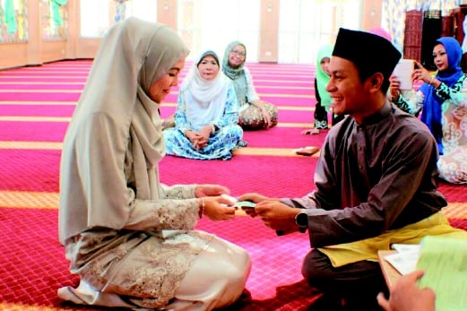 Fadhil menyerahkan wang mas perkahwinan kepada  Siti Norazlin ketika majlis pernikahan mereka.