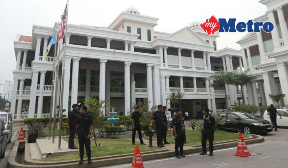 ANGGOTA polis berkawal di pekarangan Mahkamah Pulau Pinang. FOTO Danial Saad.