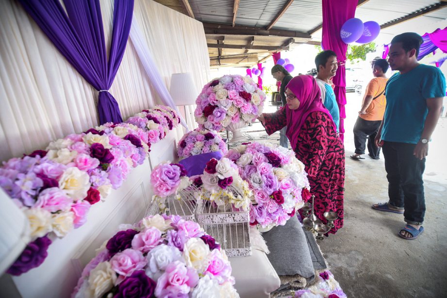 IBU pengantin lelaki, Orliyah Sali memperkemaskan halaman untuk perkahwinan anaknya walaupun dijangka berlaku fenomena air pasang besar di Kampung Tok Muda, Kapar. FOTO Muhammad Sulaiman 