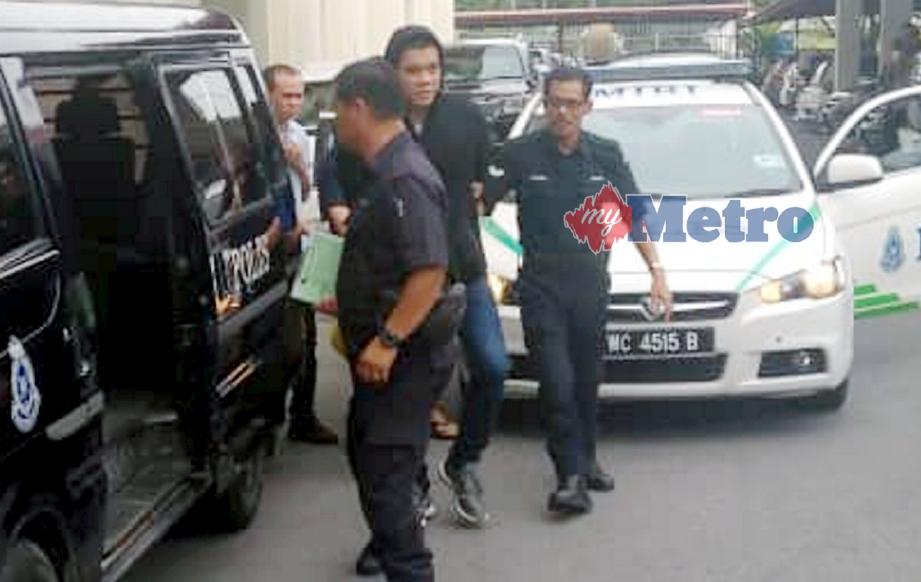 ANGGOTA polis mengiringi Mohamad Fitri (tengah) yang dijatuhkan hukuman gantung sampai mati di Mahkamah Tinggi Miri, hari ini atas kesalahan membunuh Setiausaha PKR Miri, Bill Kayong, dua tahun lalu. FOTO Mohd Rizal Abdullah. 