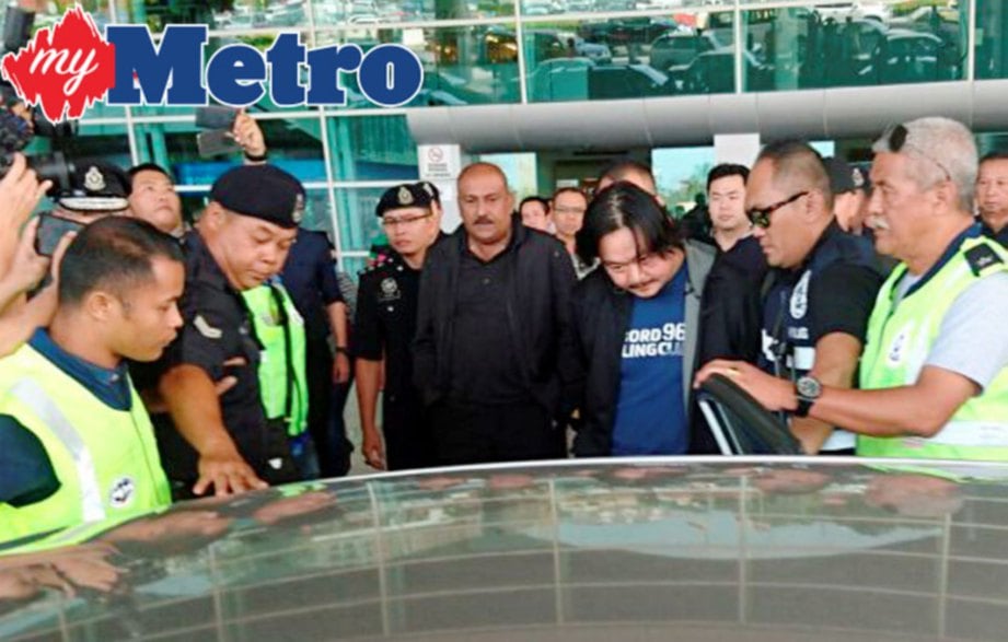Datuk Lee Chee Kiang, 45, suspek utama kes bunuh Bill Kayong dikawal ketat oleh anggota polis ketika tiba di Lapangan Terbang Miri jam 10.45 pagi tadi selepas berjaya ditahan di China. FOTO Kandau Sidi