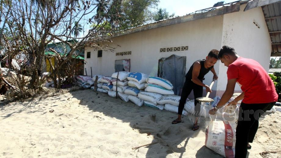 PENDUDUK Pantai Pulau Kundur membuat persiapan bagi menghadapi banjir gelombang ketiga dijangka hujung bulan ini. FOTO Zaman Huri Isa