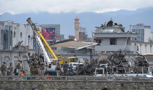 Anggota keselamatan Afghanistan memeriksa lokasi serangan bom kereta di pintu pagar bangunan kerajaan di Kabul. - Foto AFP