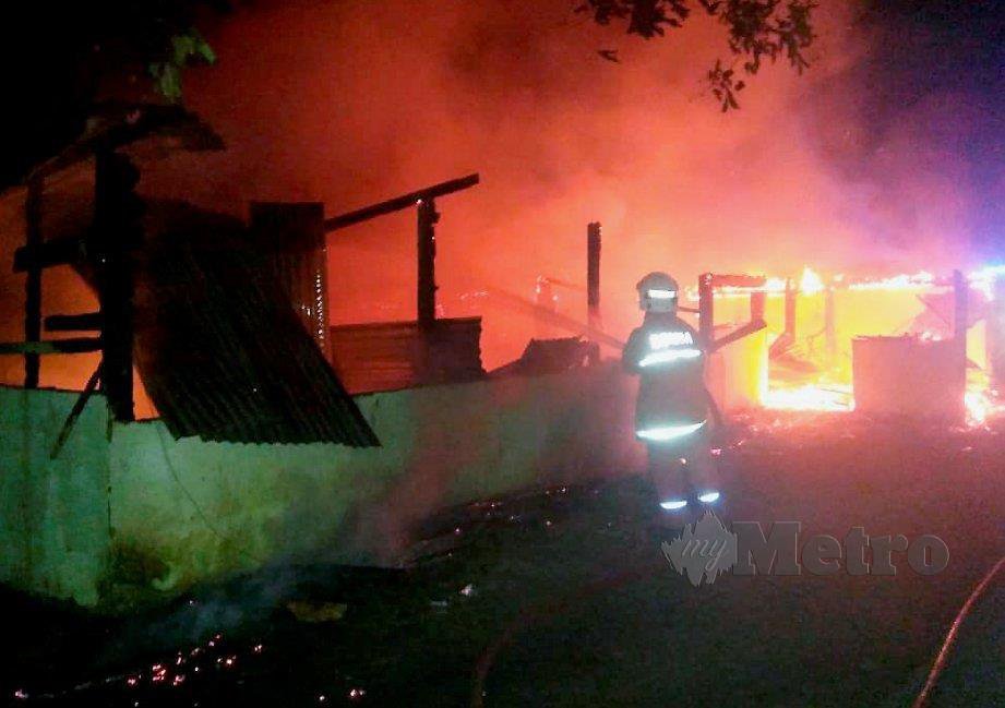 ANGGOTA bomba memadam api dalam kebakaran sebuah rumah dua tingkat di Kampung Bambangan, Jalan Lumantak. FOTO ihsan bomba 