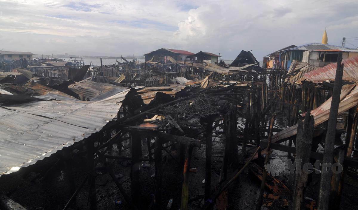 TINJAUAN di lokasi kebakaran yang memusnahkan sebanyak 73 buah rumah atas air di Kampung Lok Urai, Pulau Gaya malam tadi. FOTO Mohd Adam Arinin