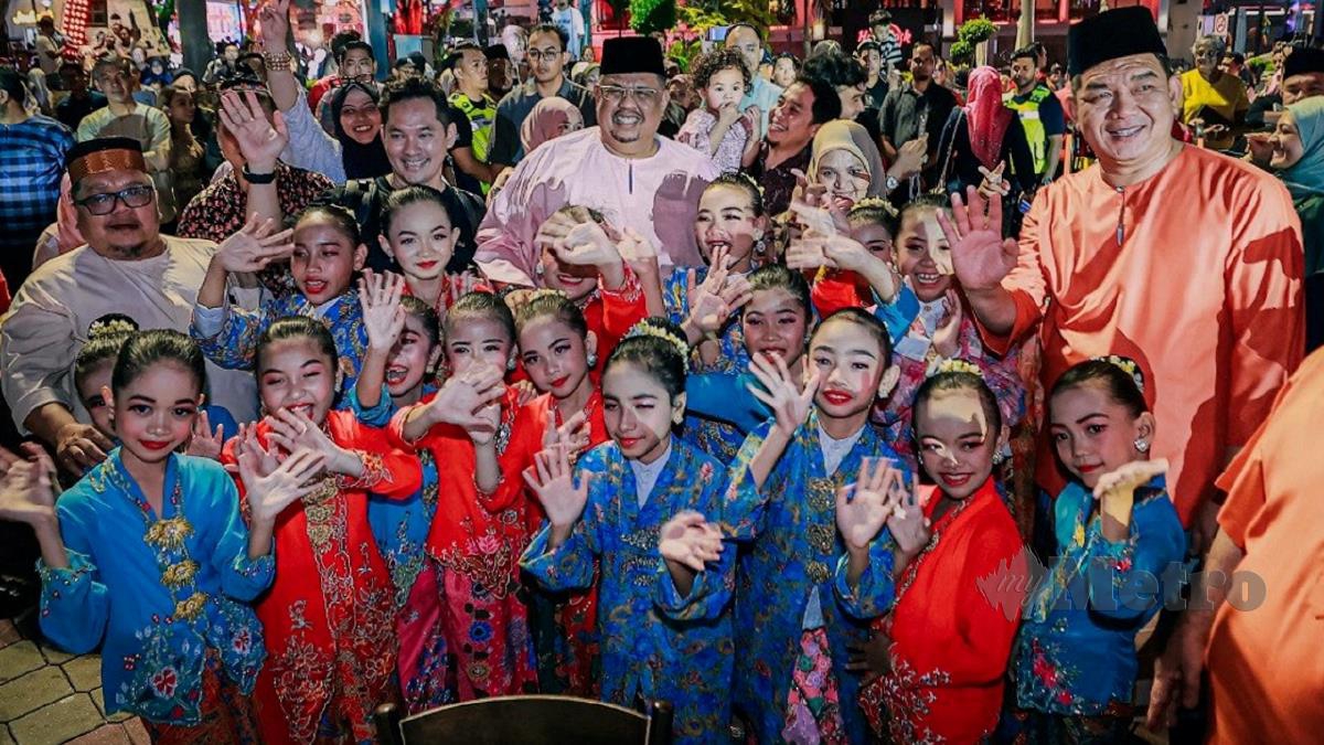 AB Rauf (tengah) bergambar bersama kanak-kanak yang berpakaian kebaya pada Pesta Kebaya dan Busana Klasik @ Melaka Heritage Festival malam tadi. FOTO Amir Mamat