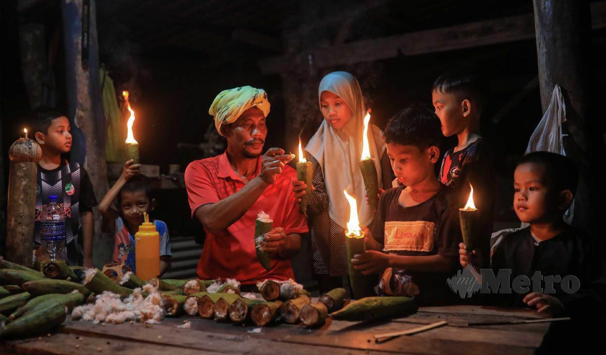 MOHD Zailani melakukan proses menyalakan pelita kekabu untuk meneruskan tradisi nenek moyang bagi membangkitkan semula nostalgia zaman kanak-kanak kebanyakan penduduk sekitar. FOTO Ghazali Kori