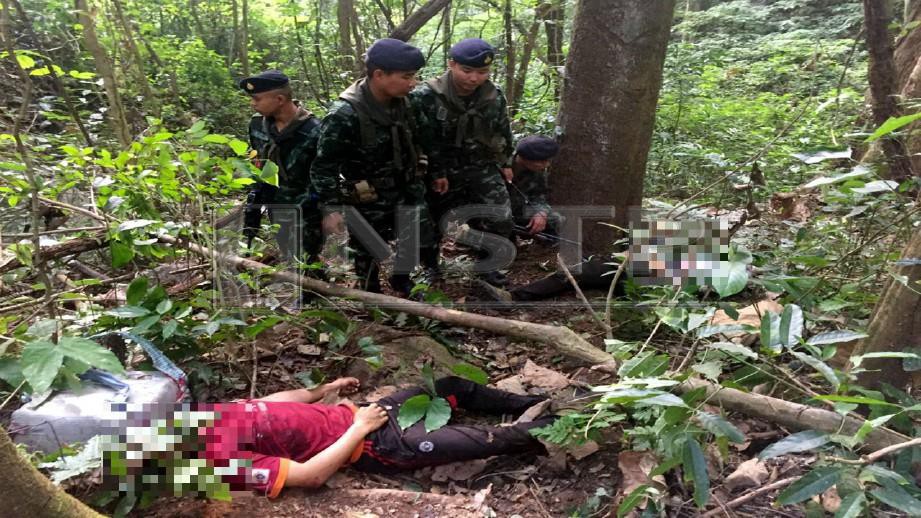 ANGGOTA tentera memeriksa mayat penghantar dadah yang maut dalam pertempuran di daerah Mae Sai, wilayah Chiang Rai di utara Thailand, malam semalam. Foto BERNAMA