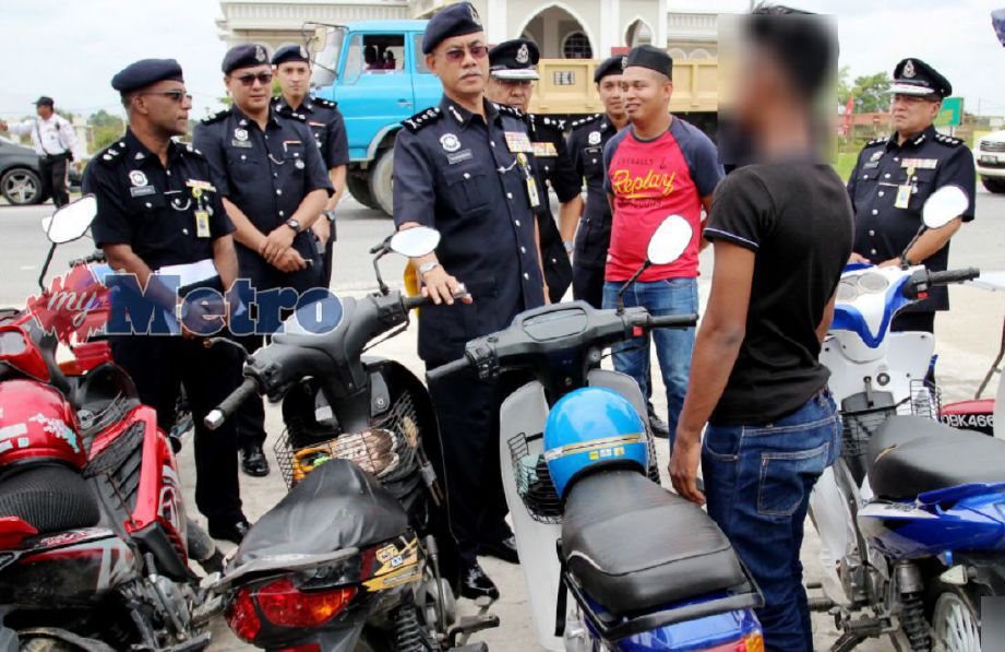 HASANUDDIN (tengah) bertanya sesuatu kepada penunggang motosikal dalam operasi trafik di Jalan Pasir Mas-Salor, Tunjong, Kota Bharu, hari ini. FOTO Nik Abdullah Nik Omar