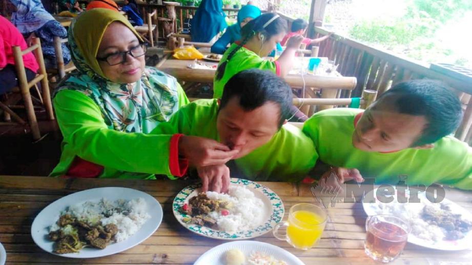 Saidatul Asmah melayan anak kembar istimewanya makan ketika hadir ke Program Korban Aidiladha 2019 anjuran YKKK dan Persatuan Sindrom Down Negeri Kelantan di Kota Bharu, semalam. Foto Hazira Ahmad Zaidi 
