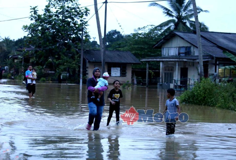 Penduduk Kampung Bukit Mentok di Kemaman mula berpindah selepas air semakin meningkat memasuki kediaman mereka. FOTO Rosli Ilham 